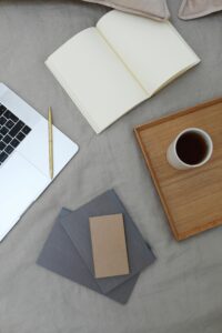 Overhead view of a minimalist workspace featuring a laptop, notebook, and coffee cup.